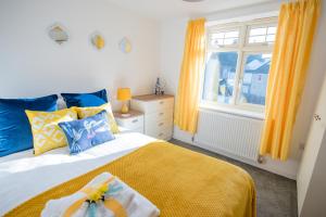 a bedroom with a bed with a yellow blanket and a window at KVM - Sunshine Apartment in Peterborough