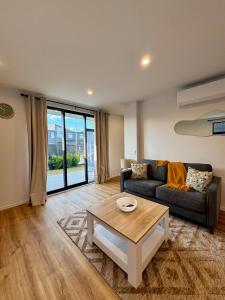 a living room with a couch and a coffee table at Luxury 2Bed2Bath Standalone Home With Parking in Christchurch