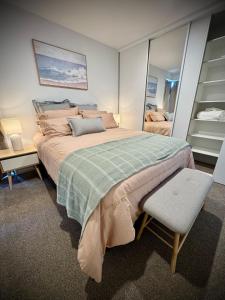 a bedroom with a large bed and a chair at Luxury 2Bed2Bath Standalone Home With Parking in Christchurch