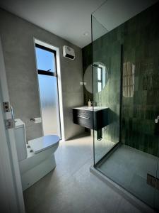 a bathroom with a sink and a glass shower at Luxury 2Bed2Bath Standalone Home With Parking in Christchurch