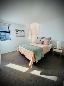 a bedroom with a large bed and a window at Luxury 2Bed2Bath Standalone Home With Parking in Christchurch