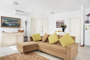 a living room with a brown couch with yellow pillows at B&B Affittacamere Via del Centro in La Maddalena