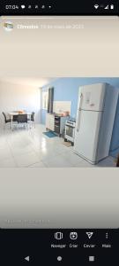 a picture of a kitchen with a refrigerator and a table at Chalé ponta verde in São José de Ribamar