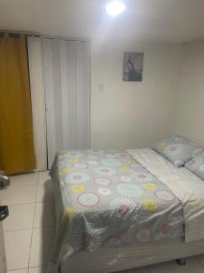 a bedroom with a bed with a flowered blanket on it at Habitación independiente cerca al mar. in Puerto Salgar