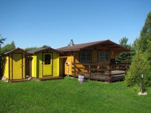 a yellow house in the grass with a yard at Kolkja Holiday Centre in Kolkja