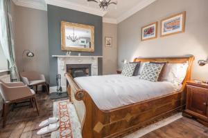 a bedroom with a bed and a fireplace at St Valery Boutique Bed + Breakfast in Alnmouth