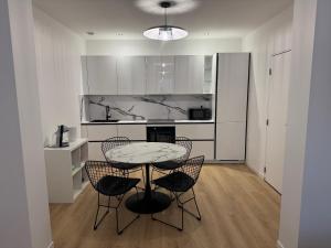 a kitchen with a table and chairs in a room at Appartement I - Haut Standing Proche Luxembourg & Cattenom in Nilvange