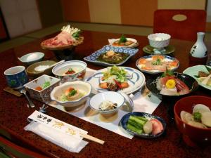 una mesa llena de platos de comida en una mesa en Kamesei Ryokan, en Chikuma