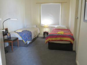 a bedroom with two beds and a window at Humble family or workers accom in Bombala