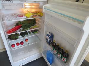 an open refrigerator filled with lots of food and drinks at Humble family or workers accom in Bombala