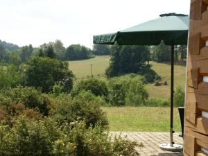 a green umbrella sitting on top of a patio at Cozy Holiday Home in Stupna with Private Garden in Stupná