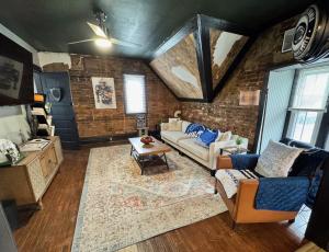 a living room with a couch and a table at Stylish, Penn State-Themed Historic Getaway 2 Blocks from Waterfront in Bellefonte
