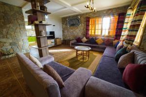 a living room with couches and a stone wall at MesklilHouse in Asilah