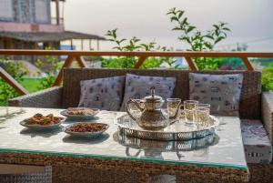 a table with a tea kettle and plates of food on it at MesklilHouse in Asilah