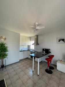 a kitchen with a table and two red stools at First line, upscale apartment Los Cristianos! 11thFloor Views in Arona