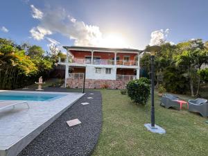 a house with a swimming pool in the yard at Villa Corail Les Abymes in Les Abymes
