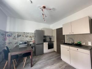 a kitchen with white cabinets and a table in it at Haus 15 Apartments Monteurwohnungen in Bielefeld