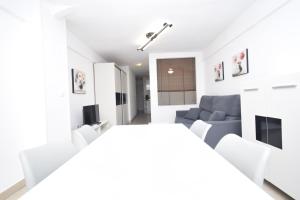 un soggiorno bianco con divano blu e sedie bianche di CABALLOS 2D - ESTUDIO - Fincas Arena a Benidorm