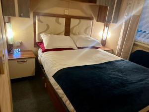 a bedroom with a large bed with a wooden headboard at 23 Chestnut Grove in Kirkcolm