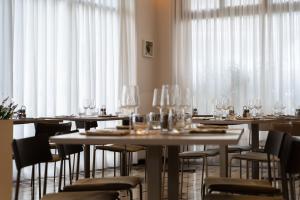 a dining room with tables and chairs with wine glasses at La Caravella in Loano