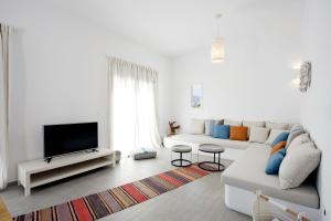 a white living room with a couch and a tv at Milis Houses in Adamantas
