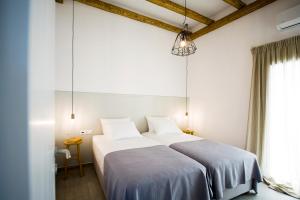 a bedroom with two beds and a large window at Milis Houses in Adamantas