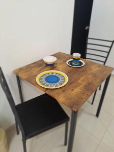 a wooden table with two cups and plates on it at Apartaestudio completo cerca Barranquilla in Galapa +2 photos