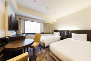 Postel nebo postele na pokoji v ubytování Kawasaki Nikko Hotel
