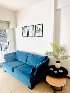 a blue couch in a living room with a potted plant at Foster Palermo Heras Suites in Buenos Aires