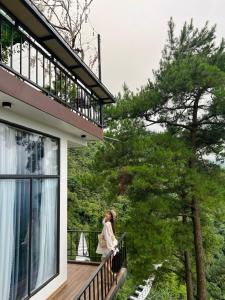 Vĩnh PhúcにあるThung Lũng Tình Yêu Homestay Tam Đảoの家のバルコニーに立つ女
