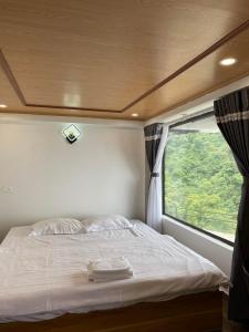 Vĩnh PhúcにあるThung Lũng Tình Yêu Homestay Tam Đảoの窓付きの部屋の真ん中のベッド