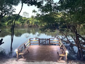 ベリーズシティにあるHowler Jungle Cabanas Belizeのライトが付いている川にかかる木製の橋
