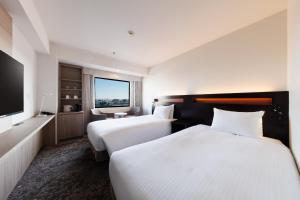 Postel nebo postele na pokoji v ubytování Kawasaki Nikko Hotel