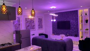 un soggiorno con illuminazione viola e pareti viola di Jnjrace a Lagos