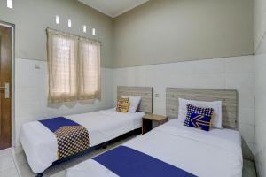 Кровать или кровати в номере OYO Life 90159 Puri Asoka Guest House