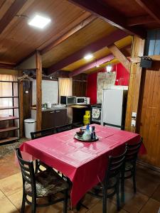 a kitchen with a table with a red table cloth at Hostal Puerta del Sol Molina in Molina