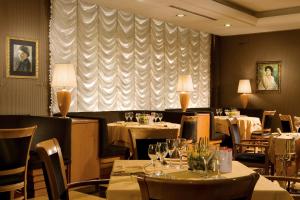 a dining room with tables and chairs and a window at Ramada by Wyndham Naples in Naples