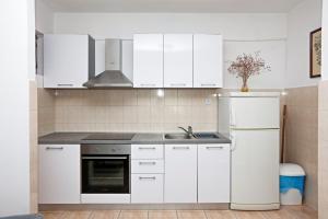 una cucina bianca con lavello e frigorifero di Apartments with a parking space Stupin Celine, Rogoznica - 23812 a Rogoznica (Rogosnizza)