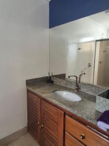 a bathroom counter with a sink and a mirror at Apartamento São Brás COP 30 in Belém