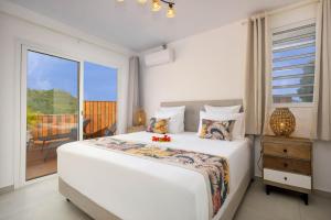 a white bedroom with a bed and a balcony at Villa Tea in Maharepa +5 photos