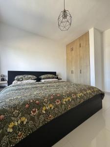 a bedroom with a large bed with a floral bedspread at Terraza Caribeña in Bayahibe +4 photos