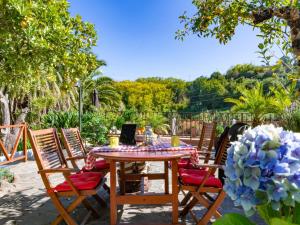 a wooden table with chairs and a table with flowers at Charming Retreat in Fontanales with Pool in Moya