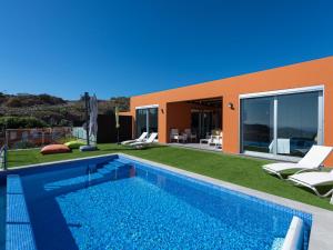 a backyard with a swimming pool and a house at Chalet in Maspalomas with Heated Pool in San Bartolomé de Tirajana