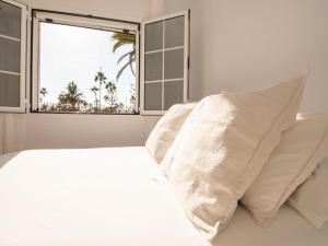 a bedroom with a white bed and a window at Bungalow in Maspalomas near Golf & Beach in San Bartolomé de Tirajana