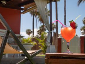 a drink on a table with a strawberry in it at Bungalow in Maspalomas near Golf & Beach in San Bartolomé de Tirajana