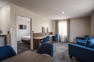 a hotel room with a bed and a desk and chairs at Heartland Hotel Auckland Airport in Auckland