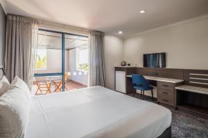 a hotel room with a large bed and a desk at Heartland Hotel Auckland Airport in Auckland