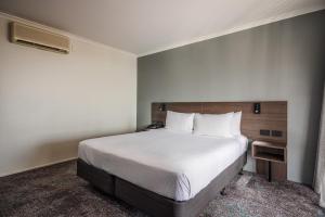 a bedroom with a large white bed in a room at Heartland Hotel Auckland Airport in Auckland