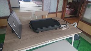einem Tisch mit Computerbildschirm und einem Aktenkoffer darüber in der Unterkunft T&T Fujiyama SAKURA in Fujiyoshida