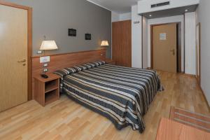 Schlafzimmer mit einem Bett, einem Schreibtisch und einer Tür in der Unterkunft Hotel Piccolo in Verona